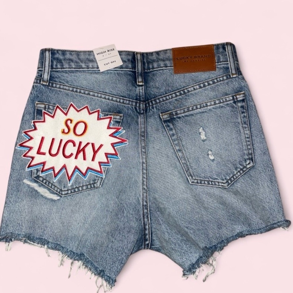 Lucky Brand High Rise Denim Shorts “So Lucky” Patch Raw Hem Size 4 / 27